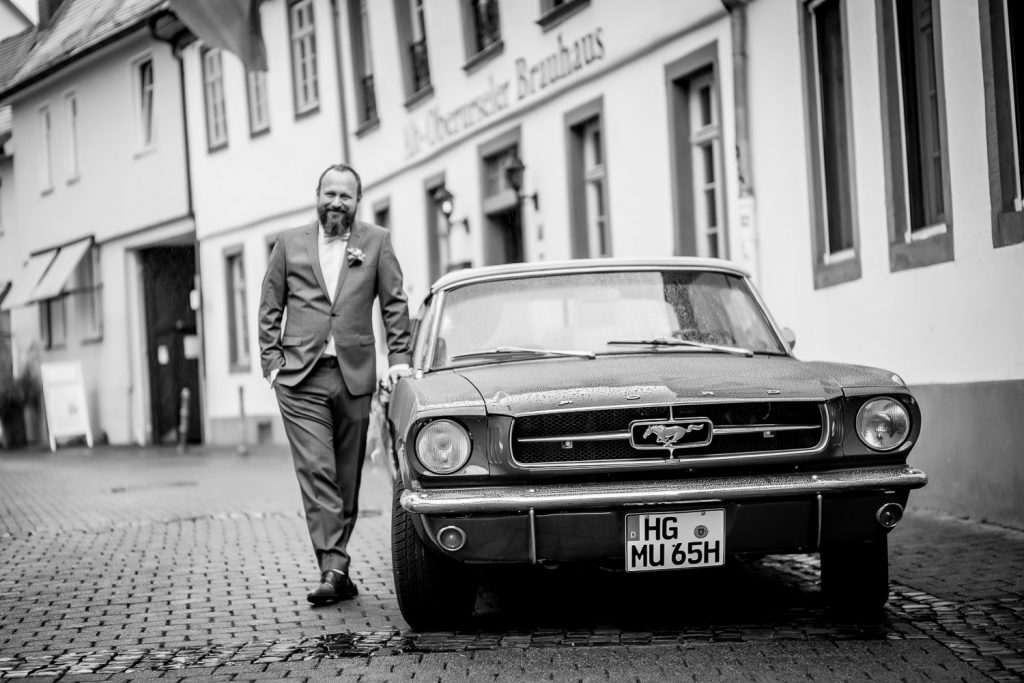 Schwarz-Weiß-Aufnahme des roten Oldtimers vor der Hochzeitslocation