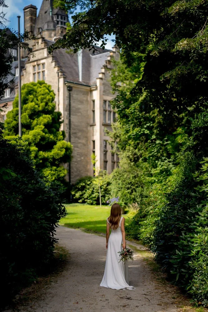 Hochzeitspaar tanzt unter Bäumen – Hochzeitsfotografie Frankfurt im Grünen.